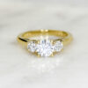 Custom Trilogy Engagement Ring with Yellow Gold Band & a Round Cut Diamond Centre Stone with Round Diamond Side Stones